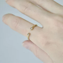 Größenverstellbarer Zirkonia-Ring in Gold an einer Frauenhand getragen