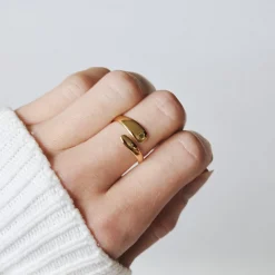Größenverstellbarer Edelstahlring in Gold an einer Frauenhand – offenes, umarmendes Design