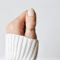 Silberner Bergspitzen Ring aus Edelstahl mit spitzer Form, getragen am Daumen einer Frauenhand