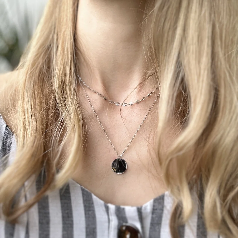 Frau trägt silberne Plättchen-Kette aus Edelstahl mit gravierbarem Anhänger im Freien